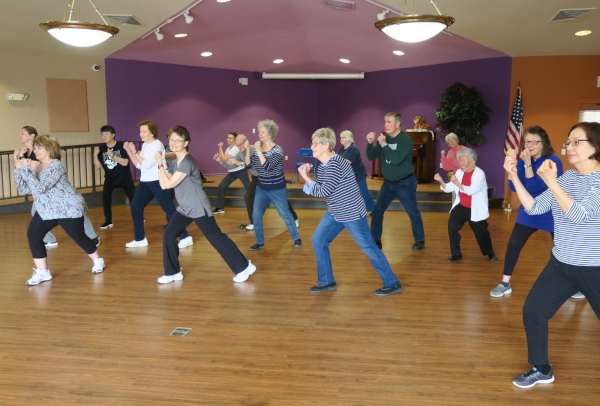 Adults participate in an aerobics class.